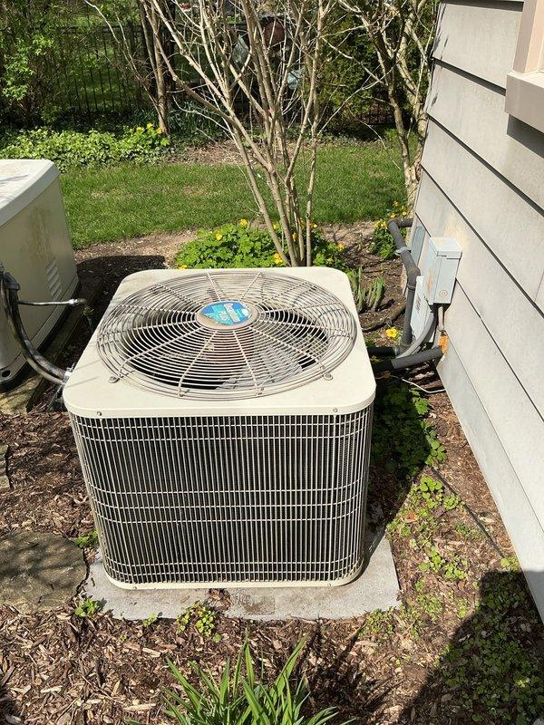 Completed comprehensive gold-level air conditioning inspection on a 10+ year old Bryant condensing unit located on exterior concrete pad with air handler/coil in basement. System currently operational at time of assessment. Documented equipment condition through photographic inspection showing condenser unit with proper clearances, secure refrigerant line connections, and adequate airflow access. Provided estimate for complete HVAC system replacement based on equipment age and homeowner consultation.