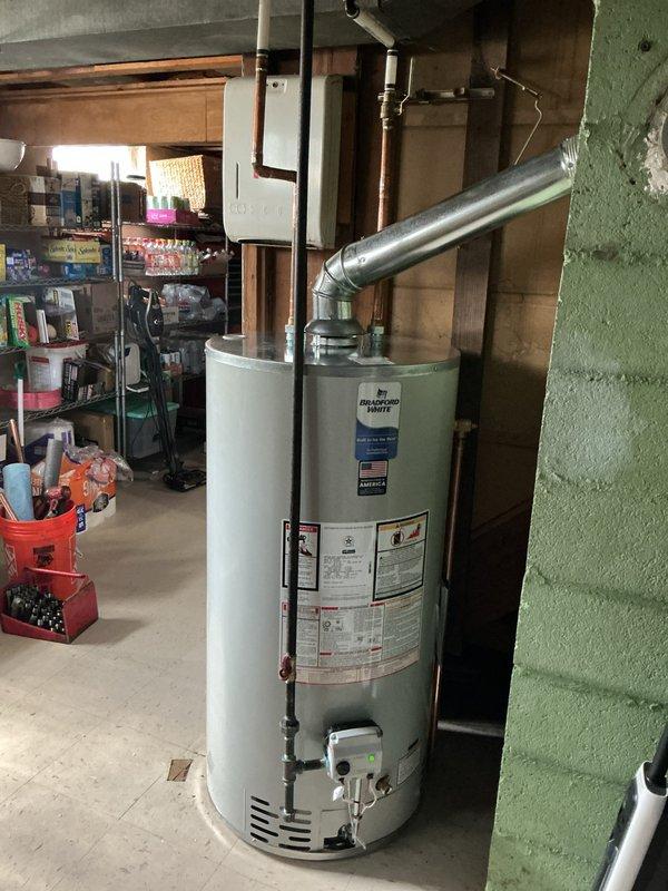 Installed a 50-gallon short Bradford White tanked water heater in basement utility area. Connected copper supply lines and exhaust venting system, ensuring all connections meet code requirements. Unit was properly positioned, secured, and tested for safe operation with all plumbing and venting systems functioning correctly.