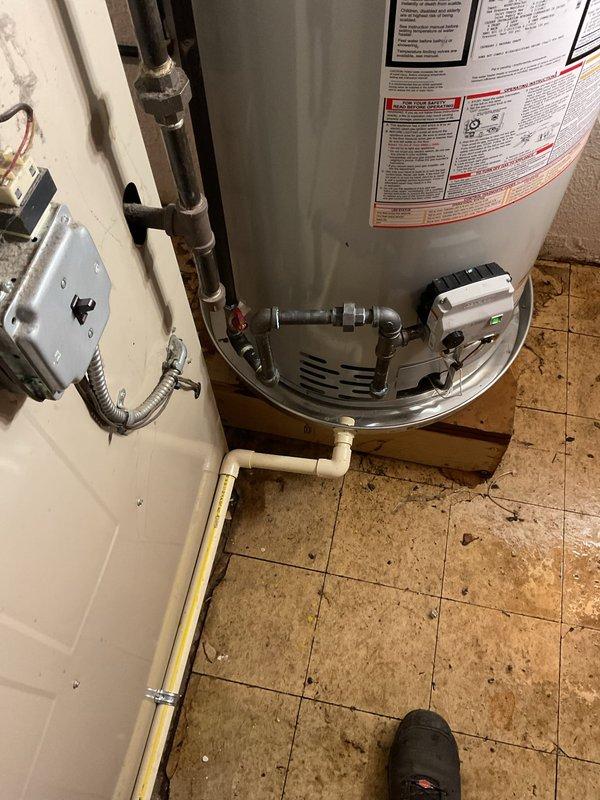 Completed installation of a 50-gallon tanked water heater in residential basement utility room. Unit was properly positioned on wooden platform with metallic drip pan, connected to existing gas line via flexible CSST connector, and vented through existing vent system. All plumbing connections, electrical controls, and safety devices were installed and reconnected per manufacturer specifications and local code requirements.