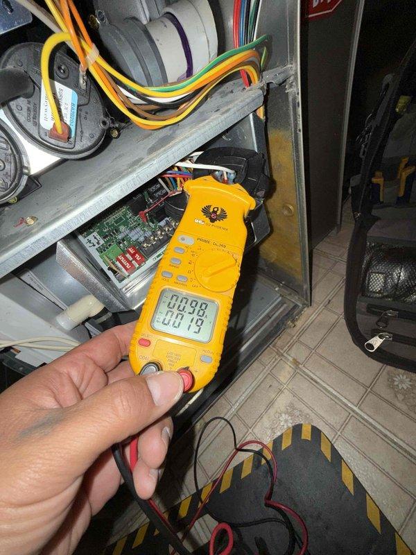 Completed comprehensive Gold AC inspection on 10+ year old residential air conditioning system with air handler located in basement. Performed electrical diagnostics using digital multimeter to verify proper voltage and amperage readings at control board and connections. Measured system temperatures, recording 77.1°F at outdoor condenser unit. Inspected all electrical components, wiring connections, circuit board functionality, and outdoor unit operation. System found to be operating within normal parameters with no immediate concerns identified. All safety checks completed and unit confirmed functional at time of inspection.