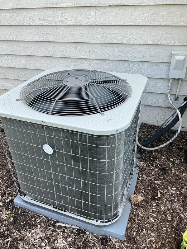 Completed comprehensive Gold AC inspection on a multi-unit residential HVAC system with air handler located in small crawlspace and basement area. Performed thorough examination of outdoor condenser unit, which was found properly positioned on concrete pad with adequate clearance and protective wire mesh guard in place. Verified system operational status, inspected electrical connections and disconnect box, confirmed proper conduit routing, and assessed overall equipment condition. Unit showed normal wear consistent with age, with no visible damage, rust, or debris accumulation on exterior surfaces or surrounding area.