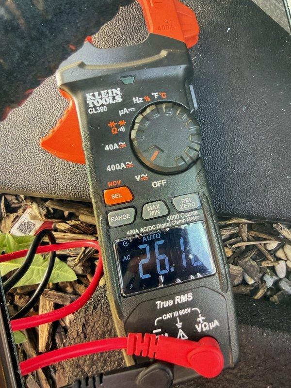 Completed air conditioning system start-up for basement evaporator coil installation. Performed electrical measurements using digital clamp meter, verifying proper amperage draw readings of 26.0A and 24.24A on the system, confirming equipment is operating within manufacturer specifications and safe operating parameters.