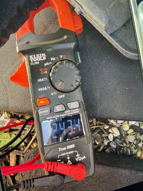 Completed air conditioning system start-up for basement evaporator coil installation. Performed electrical measurements using digital clamp meter, verifying proper amperage draw readings of 26.0A and 24.24A on the system, confirming equipment is operating within manufacturer specifications and safe operating parameters.
