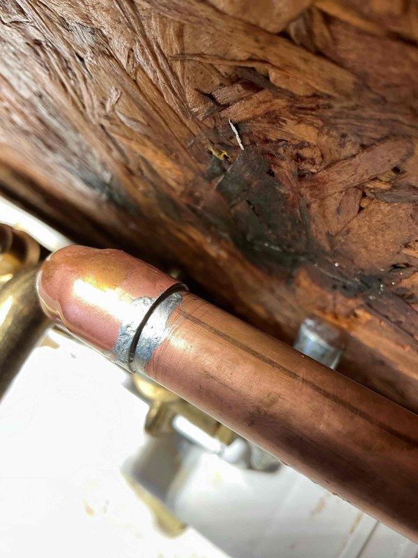 Returned to complete plumbing work following city water service restoration. Successfully completed majority of scheduled repairs with exception of #1 valve replacement, which requires city water shutoff to proceed safely. Installed copper supply lines and laundry tub rough-in above meter location, pending final connections once valve replacement is completed. Pressurized system and conducted comprehensive leak testing throughout home with satisfactory results. Identified debris accumulation in lavatory and kitchen faucets due to old galvanized piping system; both fixtures will require replacement on subsequent visit. Documented water-damaged floor joists in crawl space area near plumbing infrastructure and newly installed utility sink with dual shutoff valves mounted to OSB backing. All accessible plumbing connections functioning properly at time of departure. Advised property owner to schedule follow-up appointment once municipal water shutoff is coordinated for valve installation an