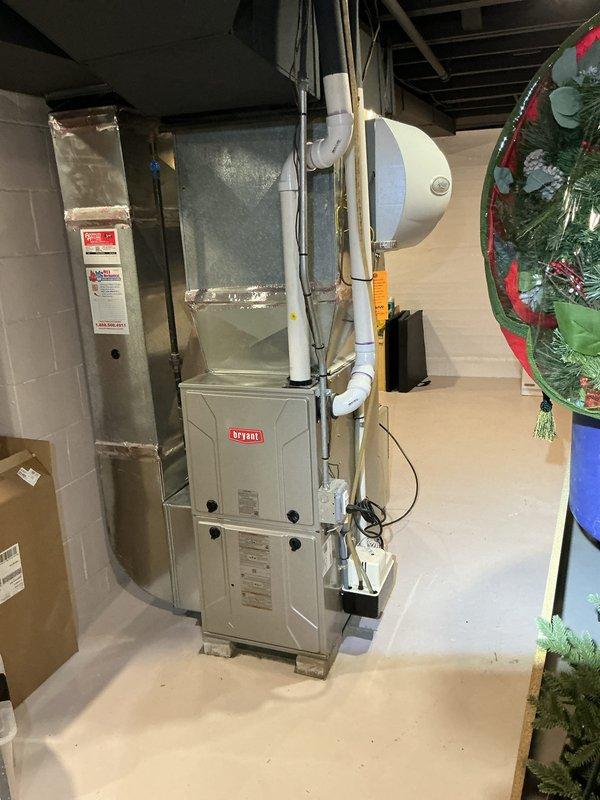 Completed Gold AC Inspection on 4-year-old Bryant HVAC system with basement-located air handler. Performed comprehensive evaluation of furnace unit, verified proper operation of Emerson programmable thermostat displaying 72°F setpoint, inspected ductwork connections and plenum assembly. Examined condensate drain lines, PVC venting system, wall-mounted expansion tank, and auxiliary equipment. All system components found operating within normal parameters. Unit confirmed functional with no immediate service requirements identified.