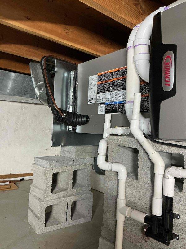 Completed full HVAC system installation including a 45,000 BTU horizontal furnace and 2-ton air conditioning unit in rear configuration. Installed humidifier, reconnected existing components, and routed all necessary ductwork, PVC condensate drainage, and electrical conduit. Unit mounted on concrete block supports in basement mechanical space with proper venting and gas connections. Mechanical permit obtained and system tested for proper operation upon completion.