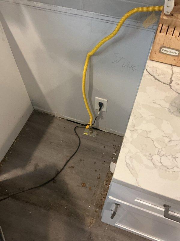 Disconnected water supply lines for dishwasher and refrigerator, and gas line for stove to facilitate flooring installation in kitchen area. Secured dishwasher mounting bracket to cabinet base using appropriate hardware. Reconnected all appliance lines upon completion of flooring work, verified proper connections and tested for leaks at all connection points.