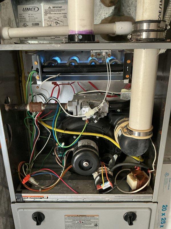 Completed comprehensive tune-up inspection on Lennox furnace system located in garage, including examination of internal components, blower motor assembly, ignition system, and all electrical connections. Inspected humidifier, thermostat, and hot water tank as requested. Documented heavily soiled air filter requiring replacement due to significant dust and debris accumulation restricting airflow; all mechanical components, wiring, and PVC venting found in operational condition with normal wear patterns.