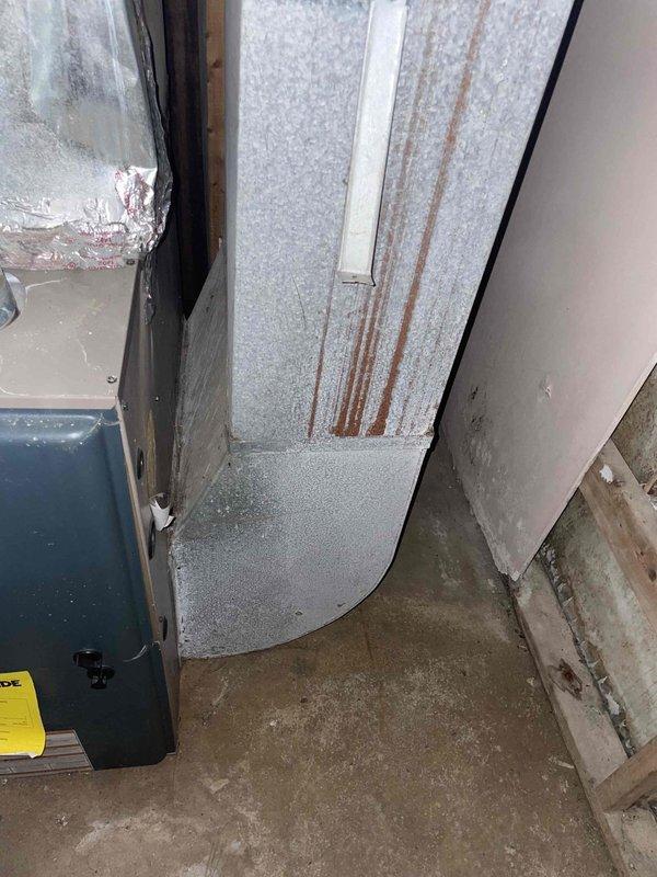 Conducted full system estimate for residential HVAC replacement. Documented extensive frost and ice buildup on main trunk ductwork in basement area, indicating significant insulation failure and potential air leakage issues. Observed moisture staining on concrete floor beneath affected ductwork and deterioration of surrounding wall materials. Inspected air handler unit showing considerable weathering, moisture staining, and surface corrosion. Photographed all equipment and problem areas for estimate documentation. Recommended complete system replacement due to age, condition, and ongoing moisture-related damage to ductwork and surrounding structure.