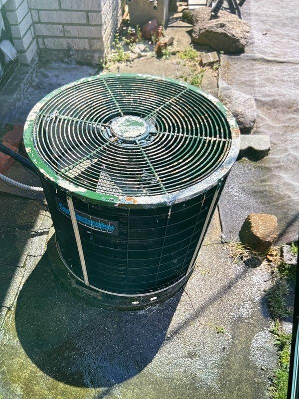 Completed comprehensive Gold AC inspection on 40-year-old residential air conditioning system with basement-located air handler. Performed thorough evaluation of outdoor condenser unit, which exhibited significant age-related wear including rust spots, paint deterioration, and surface discoloration on housing and fan grille components. Inspected refrigerant lines in basement area, documenting condition of insulated copper piping and checking for proper insulation integrity and potential condensation issues. Assessed condenser pad placement and surrounding area condition, noting weathered concrete surface with minor organic growth. Verified all accessible system components, documented equipment condition through photographic inspection, and confirmed unit operational status for continued monitoring of aging system.