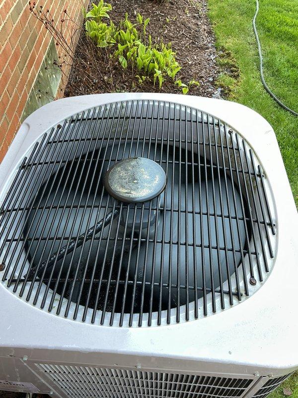 Completed comprehensive tune-up on 2016 residential HVAC system including outdoor condenser unit and basement components. Performed thorough inspection of air conditioning condenser, humidifier, thermostat, and hot water tank, verifying proper operation of all equipment. Documented unit condition with photos showing condenser in functional status with intact fan assembly and proper clearances maintained around outdoor unit.