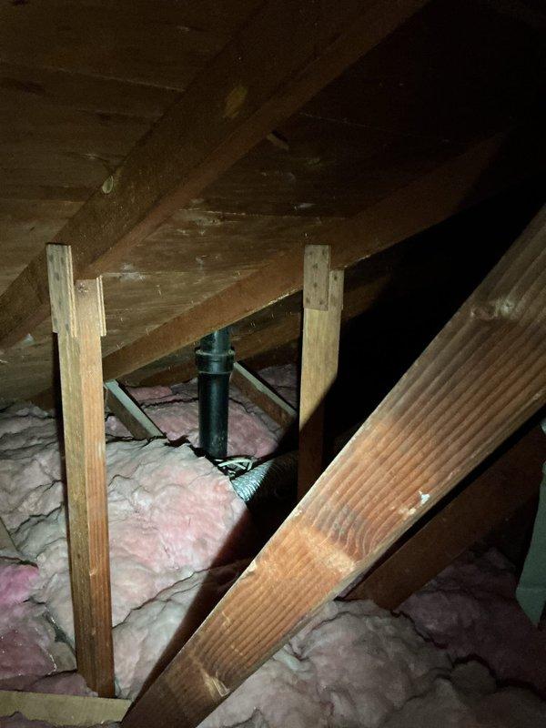 Installed condensate drain line for HVAC system in attic space following indoor comfort equipment installation. Routed PVC piping through attic framework to connect to existing plumbing infrastructure beneath kitchen sink, ensuring proper drainage and code compliance for new air conditioning unit.
