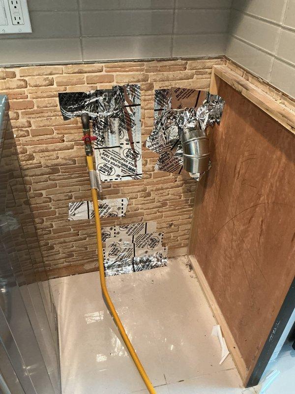 Responded to gas line repair estimate request and performed thorough inspection of existing gas line installation serving fireplace unit. Documented current configuration including brass shut-off valve with red handle, corrugated stainless steel tubing (CSST) connection, and associated fittings at wall penetration point between brick and drywall surfaces. Evaluated gas line routing from supply point through wall assembly to fireplace appliance, noting flexible gas connector installation and valve accessibility. Captured detailed photographs of gas piping components, connections, and fireplace interior to support repair estimate development and identify scope of work required for code-compliant gas line modifications or replacement.