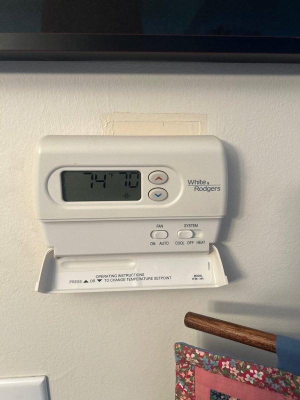 Completed AC system startup for basement air conditioning unit. Performed comprehensive startup inspection of outdoor condenser unit positioned on rubber isolation pad with proper electrical disconnect and conduit installation. Verified thermostat operation and temperature control functionality, confirmed system responding appropriately to setpoint adjustments with digital White-Rodgers control displaying proper readings and cycling between heating, cooling, and fan modes as designed.