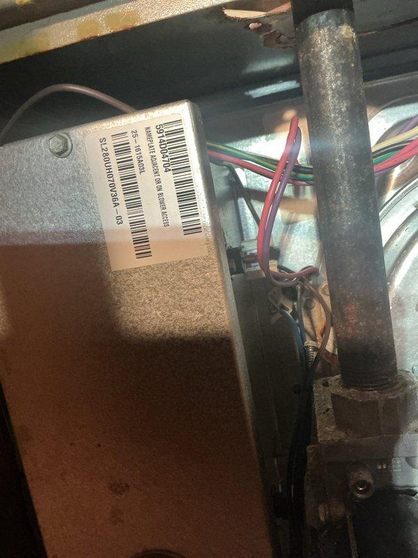 Responded to no cooling complaint on 12-year-old air conditioning system located in attic. Upon arrival, found unit completely inoperative with air handler panel open exposing control board and internal wiring. Performed diagnostic evaluation of electrical components, capacitor, and blower motor assembly. Inspected control board connections, examining red, yellow, white, and black wire terminations for loose connections or damage. Evaluated cylindrical blower motor showing signs of age-related wear and dust accumulation on housing and surrounding ductwork. Assessed condition of metallic flexible ductwork exhibiting yellowing and material deterioration consistent with system age. Documented equipment condition through photographs showing exposed circuit board, wiring harnesses, and mechanical components for service records. System required comprehensive troubleshooting to identify root cause of complete system failure and restore cooling operation.