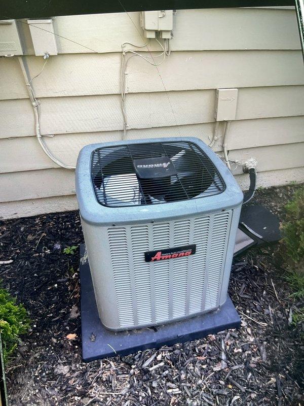 Completed comprehensive inspection and preventive maintenance on 7-year-old Amana air conditioning system and hot water tank. AC unit inspection included examining outdoor condenser positioned on concrete pad, verifying proper refrigerant line connections, checking electrical conduit and disconnect box functionality, and assessing overall equipment condition. Confirmed unit operational status with no immediate concerns noted. Performed hot water tank flush to remove sediment buildup and maintain heating efficiency. All equipment found to be in working order with appropriate weathering for age and outdoor exposure.