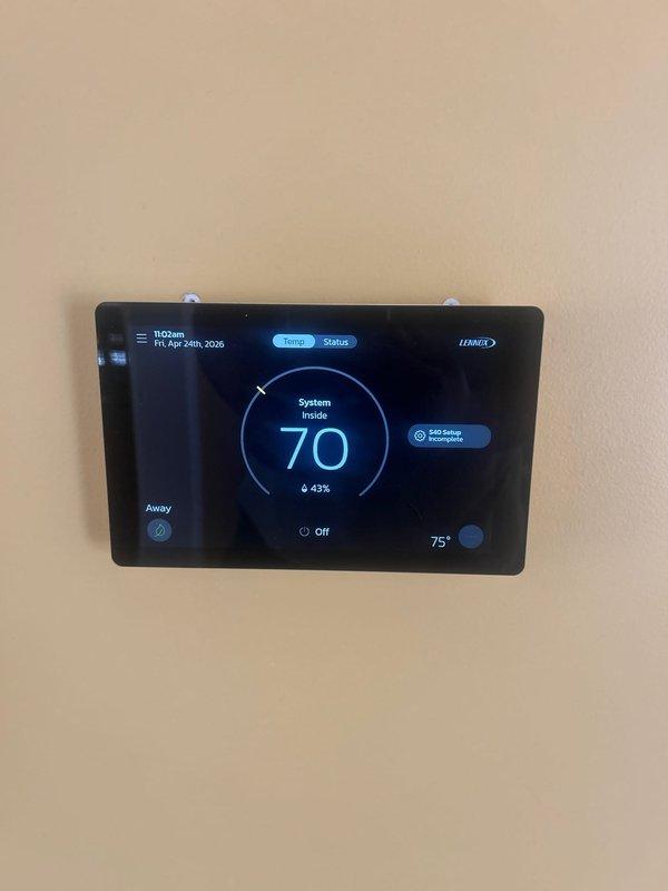 Completed air conditioning system startup on newly installed Lennox equipment. Performed initial system commissioning on outdoor condenser unit with proper electrical disconnect installation and verified all connections secure. Programmed and configured Lennox digital thermostat to operational parameters, confirmed system communication and control functionality at 70°F setpoint with proper stage operation indicated.