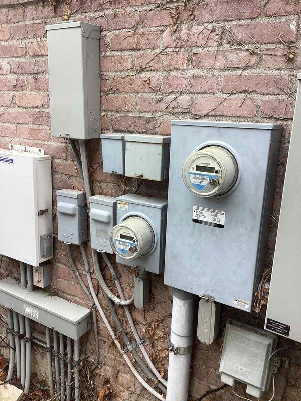 Completed comprehensive site assessment for full HVAC system replacement on residential property with dual-zone configuration. Documented existing two-unit system setup, including furnace installation in basement utility area with associated ductwork, water heater, and mechanical connections. Photographed exterior electrical service infrastructure showing dual meter configuration and conduit routing to support equipment specifications. Evaluated current system layout, structural considerations, and utility connections to develop accurate replacement proposal for whole-home heating and cooling solution.