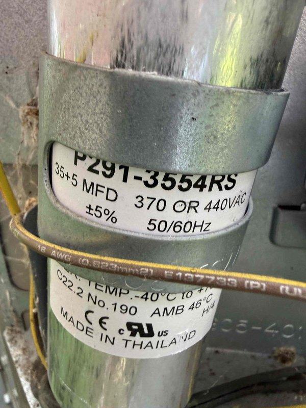 Completed comprehensive Gold AC inspection on 13-year-old Bryant air conditioning system with air handler located in basement. Performed thorough evaluation of outdoor condenser unit, including inspection of compressor, fan motor operation, and electrical components. Examined capacitor specifications (370/440VAC, 85+5 MFD) and verified proper electrical connections, noting age-related wear and minor surface oxidation on capacitor housing consistent with unit age. Confirmed condenser unit positioned properly on platform with adequate clearance, PVC condensate line routing appropriately, and surrounding area clear of debris. Assessed overall system operation and component condition, documenting equipment status through photographic records for maintenance history.
