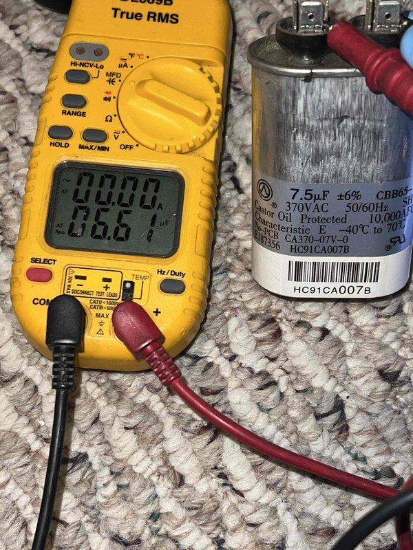 Completed Gold AC Inspection on 19-year-old single HVAC system with air handler located in basement. Performed comprehensive diagnostic testing including capacitor testing using digital multimeter, which measured 7.5μF capacitor at 370VAC specifications. Inspected ductwork, metal housing components, and system operation. Unit was operational at time of inspection with all components functioning within normal parameters. Documented system measurements and specifications on equipment housing for maintenance records.