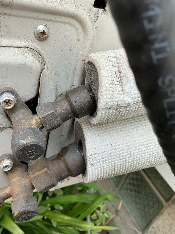 Responded to no cooling complaint on mini-split system located in upstairs bedroom. Performed diagnostic inspection of indoor wall-mounted evaporator unit and outdoor condensing unit. Inspected refrigerant line connections at outdoor unit, noting accumulated dirt and debris on equipment housing and service valves. System evaluated and findings documented with photographic evidence for customer records.
