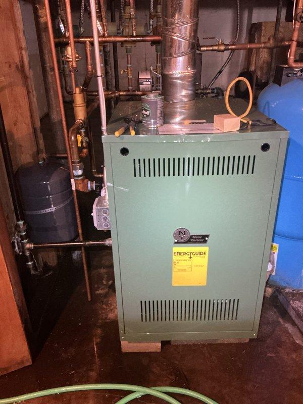 # HVAC Service - Water Leak

Responded to service call for reported water leak on residential boiler system located in basement. Upon arrival, performed comprehensive diagnostic inspection of green-painted boiler unit and associated hydronic heating system components. 

Conducted thorough visual examination of all copper piping connections, circulator pumps, pressure relief valve, expansion tank connections, and zone valves to identify source of water leak. Inspected pressure gauge readings and assessed system pressure. Examined all threaded connections, compression fittings, and solder joints throughout the piping network for signs of active leaking or moisture accumulation.

Checked expansion tank for proper air charge and inspected tank connection point for potential leak source. Evaluated condition of pressure relief valve discharge pipe and tested valve operation. Inspected all visible gaskets, seals, and union connections on boiler cabinet and associated piping.

Documented equip