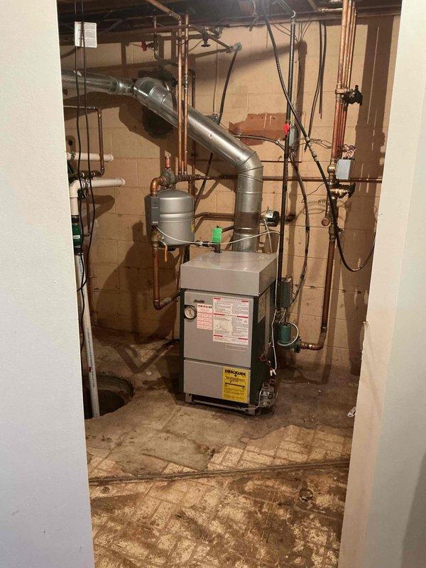 Responded to service call for leaking pressure relief valve on 20-year-old hot water boiler located in basement near sump pump. Performed diagnostic inspection of boiler system and pressure relief valve assembly, utilizing digital testing equipment to assess system pressure and operational parameters. Documented existing conditions of heating equipment, associated copper piping, and valve connections for homeowner records.