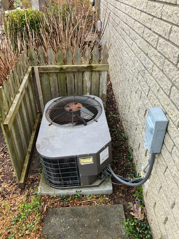 Provided estimate for replacement of 20-year-old residential air conditioning and furnace system. Existing outdoor AC unit located on concrete pad against exterior wall shows significant weathering and age-related deterioration. Natural gas furnace currently installed in basement requires replacement along with outdoor condensing unit to restore efficient cooling and heating operation.