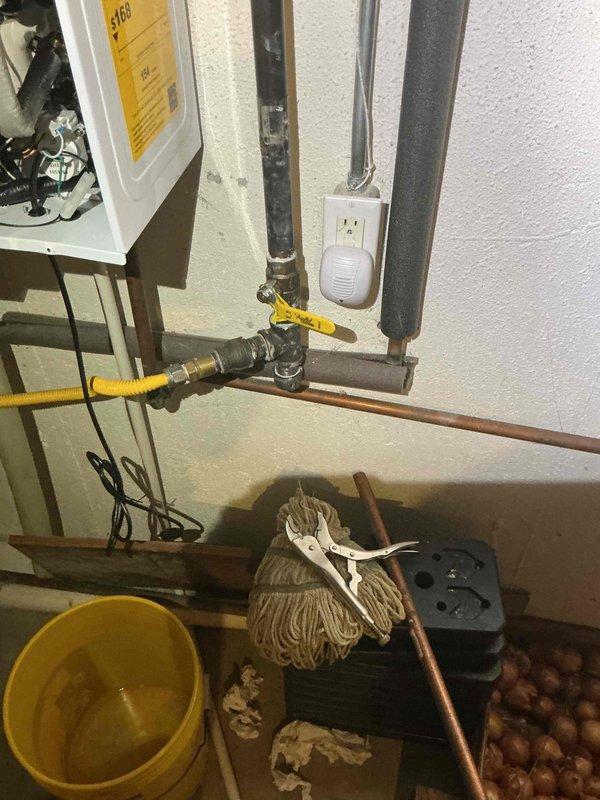 Responded to no hot water complaint on Navien tankless water heater system. Upon arrival, inspected unit and verified customer concern regarding lack of hot water production. Opened front access panel to examine internal components, valves, and mechanical assemblies for proper operation. Checked gas supply line connection with yellow flex connector and verified shut-off valve position. Inspected electrical connections, control panel functionality, and mounting configuration. Evaluated water inlet and outlet piping connections along with associated plumbing infrastructure. Performed diagnostic assessment of unit to identify cause of no hot water condition and determined necessary corrective action to restore proper heating function.