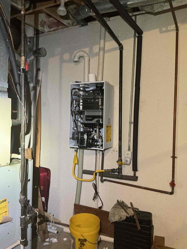 Responded to no hot water complaint on Navien tankless water heater system. Upon arrival, inspected unit and verified customer concern regarding lack of hot water production. Opened front access panel to examine internal components, valves, and mechanical assemblies for proper operation. Checked gas supply line connection with yellow flex connector and verified shut-off valve position. Inspected electrical connections, control panel functionality, and mounting configuration. Evaluated water inlet and outlet piping connections along with associated plumbing infrastructure. Performed diagnostic assessment of unit to identify cause of no hot water condition and determined necessary corrective action to restore proper heating function.