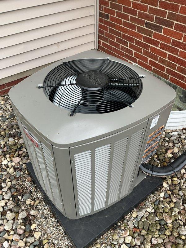 Completed comprehensive Gold AC inspection on a 1-year-old residential air conditioning system with outdoor condenser unit and basement air handler. Performed visual inspection of exterior condenser unit, confirming proper installation on rubber isolation pad with adequate clearance, verified ventilation louvers are unobstructed, and documented equipment condition showing no visible damage, rust, or deterioration. Unit operational with all components functioning within normal parameters.