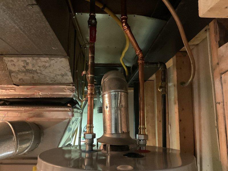 Responded to service call for temperature inconsistency on tanked water heater installed in 2016. Customer reported water excessively hot on high setting and inadequate temperature on medium setting, with warm water transitioning to cold during use. Issue began approximately 1.5 days prior to service call.

Upon inspection of the unit located in attic space, evaluated copper supply lines, temperature control components, and valve assemblies. Assessed thermostat functionality and heating element performance to diagnose temperature regulation failure. Examined plumbing connections, shut-off valves, and pressure relief components for proper operation. Verified gas supply connections and burner assembly operation. Tested both upper and lower heating elements and thermostats for proper cycling and temperature maintenance. Adjusted thermostat settings and verified proper differential between high and medium temperature selections. Confirmed adequate hot water delivery and consistent temperat