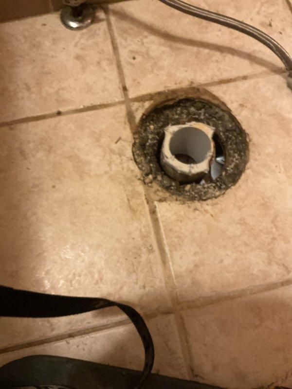 Responded to water leak complaint originating from toilet installation with water penetrating through to basement level. Upon inspection, identified active leak at toilet base with water migrating through floor assembly and draining into basement space below. Photographic documentation revealed water damage and staining on PVC drain pipe and surrounding floor joists in basement ceiling cavity, along with deteriorated condition of floor drain and buildup around toilet mounting area. Diagnosed compromised wax ring seal at toilet flange connection as primary leak source. Removed toilet fixture, replaced failed wax ring seal, inspected toilet flange for damage and proper alignment, reinstalled toilet with new mounting hardware, and verified proper seal. Tested system with multiple flush cycles to confirm leak elimination and proper drainage function.