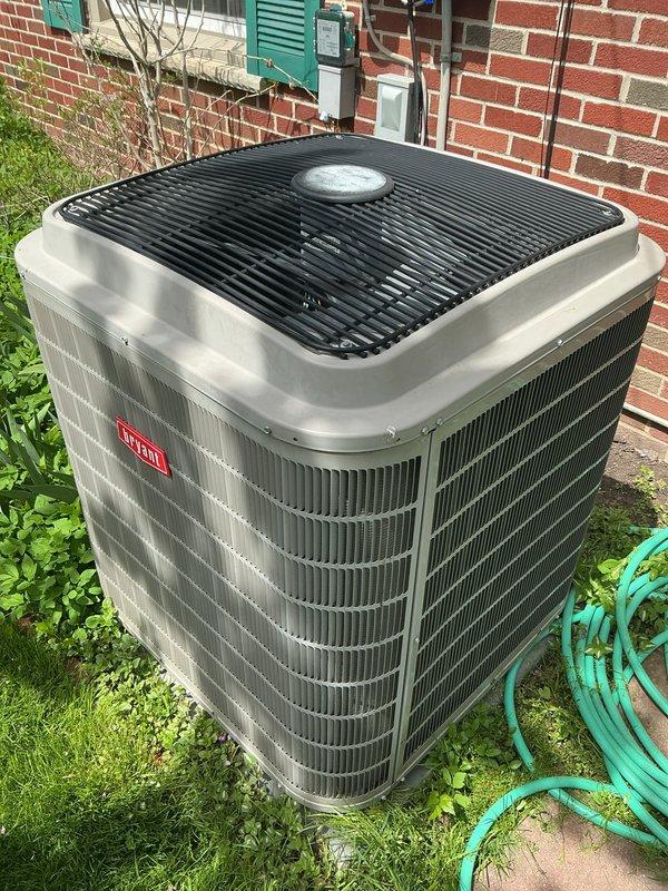 Completed comprehensive Gold AC Inspection on a 9-year-old Bryant residential air conditioning system. Performed thorough examination of outdoor condenser unit positioned on concrete pad against brick exterior, confirmed proper installation with adequate clearance and secure mounting. Inspected electrical disconnect box, conduit, and refrigerant line sets for proper routing and connections. Evaluated condenser coil fins for cleanliness and damage, assessed fan grille and motor operation, and verified overall unit condition showing good maintenance with no visible signs of deterioration, rust, or structural damage. Confirmed system operational status with homeowner, documented basement-located air handler/coil configuration. Equipment demonstrated satisfactory performance with no immediate service needs identified during inspection.