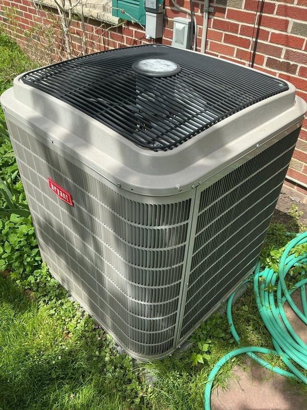 Completed comprehensive Gold AC Inspection on a 9-year-old Bryant residential air conditioning system. Performed thorough examination of outdoor condenser unit positioned on concrete pad against brick exterior, confirmed proper installation with adequate clearance and secure mounting. Inspected electrical disconnect box, conduit, and refrigerant line sets for proper routing and connections. Evaluated condenser coil fins for cleanliness and damage, assessed fan grille and motor operation, and verified overall unit condition showing good maintenance with no visible signs of deterioration, rust, or structural damage. Confirmed system operational status with homeowner, documented basement-located air handler/coil configuration. Equipment demonstrated satisfactory performance with no immediate service needs identified during inspection.