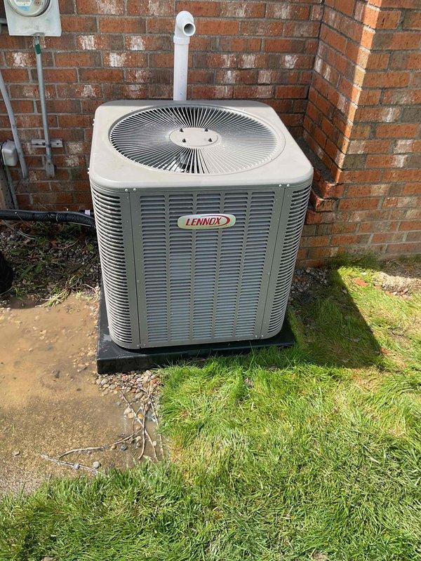 # HVAC Maintenance - Gold AC Inspection

Completed comprehensive Gold-level air conditioning inspection on a 10-year-old Lennox outdoor condensing unit with air handler located in basement. Upon arrival, found condenser coil heavily soiled with substantial accumulation of dirt, dust, and organic debris, with fins showing significant darkening and discoloration throughout. Unit positioned on concrete pad against exterior brick wall with adequate clearance. Performed thorough visual assessment of condenser cabinet, fan grille assembly, and refrigerant line connections. Documented unit condition including exterior panel integrity, mounting stability on pad, and surrounding drainage areas. Electrical disconnect and conduit connections inspected and found secure at wall-mounted junction point. White PVC condensate drain line verified extending from unit top. Captured detailed photographic documentation of coil contamination level and overall equipment condition for service records. Unit ope