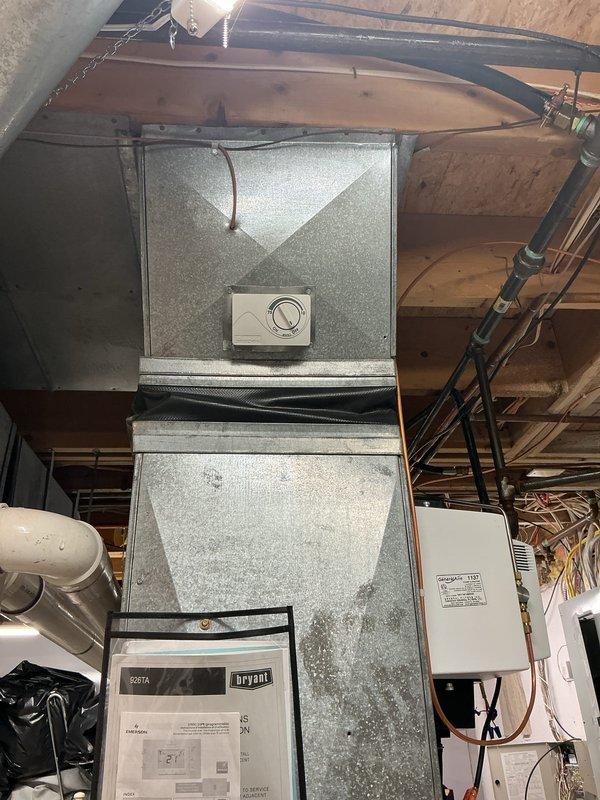 Completed comprehensive Gold AC inspection on basement-located HVAC system with Bryant equipment. Performed full system evaluation including thermostat operation verification at Emerson digital control set to 71 degrees, visual inspection of furnace unit and air handler components, assessment of ductwork connections, and examination of electrical connections at junction box. All components photographed and documented, system found operational with no immediate service requirements identified during inspection.