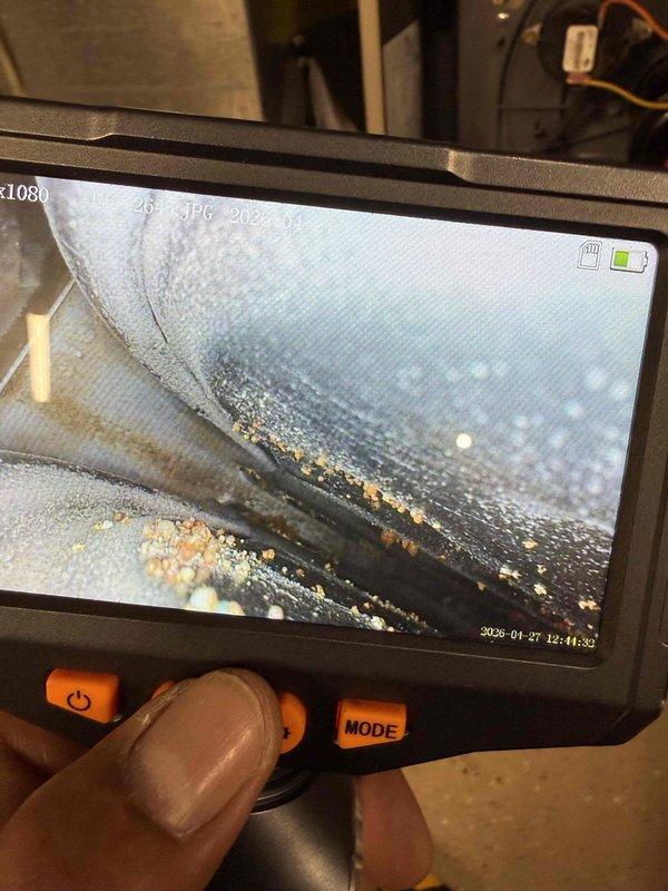 # No Heat Call - 23-Year-Old Furnace

Responded to no heat call for 23-year-old furnace system. Upon arrival, confirmed unit was completely non-operational. Performed comprehensive diagnostic inspection of all major components and systems.

Utilized borescope inspection camera to examine internal heat exchanger condition and flue passages. Camera inspection revealed significant moisture accumulation and yellowish-brown debris deposits throughout interior surfaces of heat exchanger, indicating advanced deterioration and potential combustion byproduct buildup. This contamination pattern is consistent with age-related failure in units exceeding recommended service life.

Inspected gas supply line, shut-off valve, and copper piping connections at furnace cabinet. Examined all visible safety labels and manufacturer specifications. Documented equipment condition through photographic evidence showing valve assembly, gas line configuration, and cabinet access points.

Given the unit's age of 2