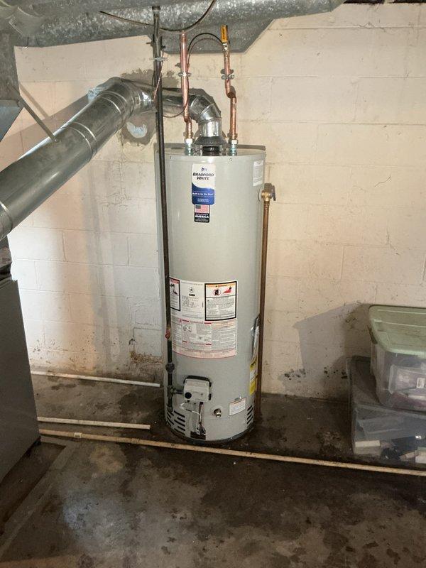 Successfully completed a 40-gallon tanked water heater replacement in a basement utility area. The original unit exhibited significant deterioration with extensive rust staining throughout the tank exterior, indicating advanced age and potential structural compromise that necessitated immediate replacement.

Removed the existing water heater and installed a new 40-gallon residential gas-fired tanked water heater. Connected all copper supply lines with proper brass fittings and installed pressure relief valve per manufacturer specifications and local code requirements. Verified all plumbing connections for proper seal and tested for leaks. Connected exhaust venting system to ensure safe combustion gas evacuation from the space.

The customer was informed that this installation does not include chimney liner or chimney cap, and these components may require additional work if determined necessary during future inspection. All connections were pressure tested and the unit was fired up to v