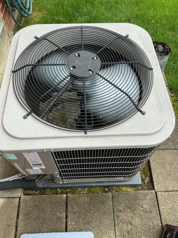 # HVAC Maintenance - Gold AC Inspection

Performed comprehensive Gold-level preventive maintenance inspection on an 8-year-old residential split-system air conditioning unit. System was operational upon arrival with air handler and evaporator coil located in basement. Conducted thorough visual assessment of outdoor condenser unit positioned on paver stone patio. Inspected exterior cabinet condition, noting minimal weathering consistent with age and outdoor exposure. Evaluated condenser coil fins and louvers for debris, damage, and airflow obstruction. Examined top-mounted fan assembly and protective wire guard for proper installation and structural integrity. Verified manufacturer's data plate visibility and legibility for future service reference. Assessed refrigerant line connections and electrical disconnect for secure mounting and proper insulation. Confirmed adequate clearance around unit for proper airflow and serviceability. Documented equipment condition through photographic re