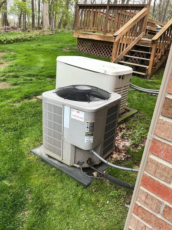 Completed comprehensive Gold AC inspection on 12-year-old residential air conditioning system with basement-mounted air handler. Performed thorough evaluation of outdoor condenser unit positioned on concrete pad alongside standby generator in backyard setting. Inspected refrigerant lines, electrical connections, and conduit routing from exterior unit to house. Verified proper operation of condenser fan motor and assessed overall system performance. Examined equipment mounting, concrete pad condition, and clearances around unit. Documented equipment condition through photographic records showing weathering consistent with age but functional components. System confirmed operational at time of inspection with no immediate service needs identified.