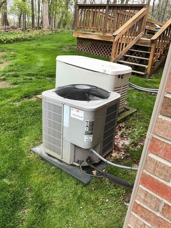 Completed comprehensive Gold AC inspection on 12-year-old residential air conditioning system with basement-mounted air handler. Performed thorough evaluation of outdoor condenser unit positioned on concrete pad alongside standby generator in backyard setting. Inspected refrigerant lines, electrical connections, and conduit routing from exterior unit to house. Verified proper operation of condenser fan motor and assessed overall system performance. Examined equipment mounting, concrete pad condition, and clearances around unit. Documented equipment condition through photographic records showing weathering consistent with age but functional components. System confirmed operational at time of inspection with no immediate service needs identified.