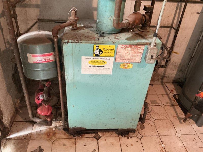 Conducted estimate evaluation for natural gas boiler system located in basement. Existing unit is over 10 years old, currently operational, showing visible signs of age including rust staining on metal components and base area. Documented equipment condition including expansion tank, piping configuration, and valve assemblies to provide replacement options and system upgrade recommendations.