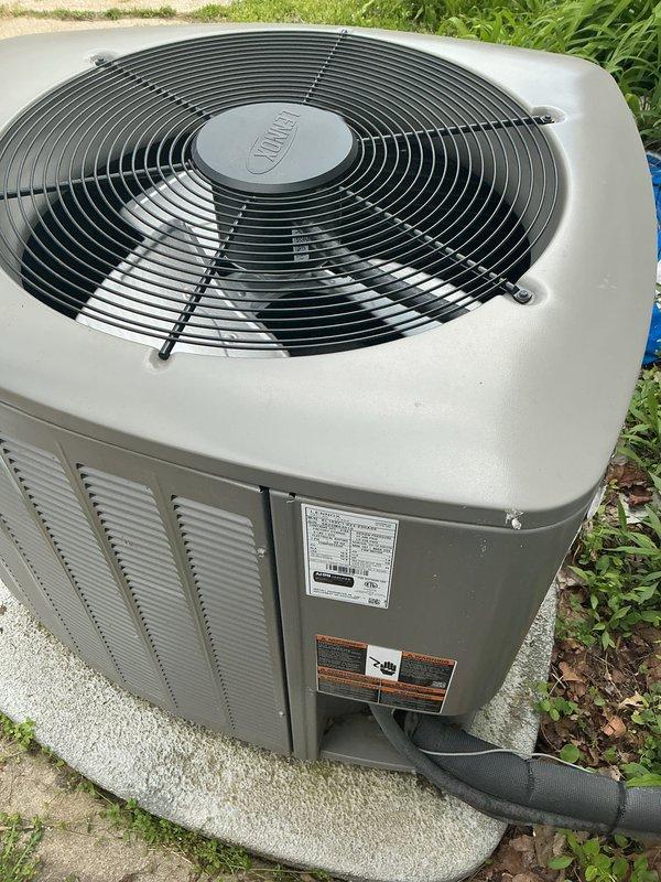 Completed NSP air conditioning inspection on 2-year-old system with coil located in utility room. Unit inspected as part of back-to-back service call arrangement for two properties on same street. Outdoor condensing unit found in excellent operating condition with no visible signs of wear, damage, or deterioration. All components including fan assembly, protective grilles, cabinet panels, and ventilation louvers inspected and confirmed to be functioning properly. Unit properly positioned on concrete pad with adequate clearance and drainage. System photographed and documented for service records.