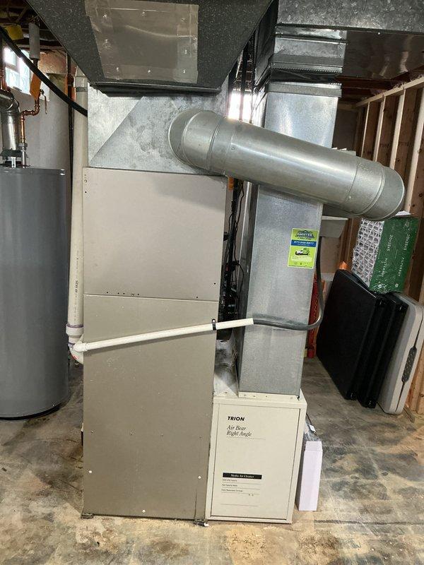 Conducted comprehensive assessment of existing 20-year-old furnace system located in basement mechanical room for replacement estimate. Documented current HVAC installation including air handler unit, associated ductwork configuration with galvanized metal supply runs along exposed ceiling joists, and existing infrastructure layout. Evaluated equipment accessibility, electrical connections, gas line routing, condensate drainage system, and existing duct connections to determine optimal replacement specifications and installation requirements for new high-efficiency furnace system.