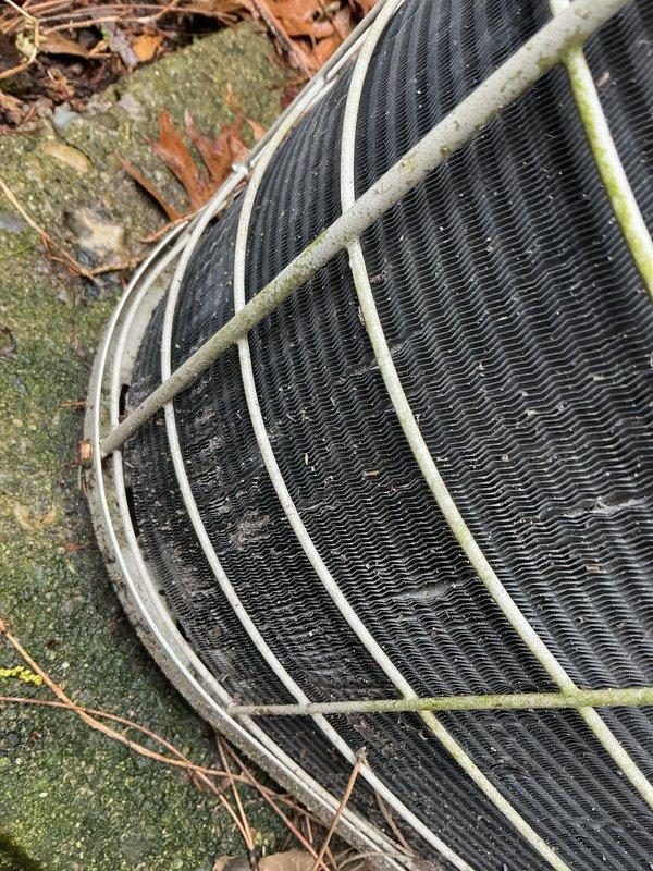 Completed comprehensive Gold AC Inspection on two 30-year-old air conditioning systems, one located in basement and one in attic. Performed thorough evaluation of both units including inspection of condenser coils, fan assemblies, electrical connections, refrigerant levels, and overall system operation. Exterior condenser unit showed significant accumulation of organic debris, moss growth on surrounding surfaces, and weathering on protective grills with visible corrosion on mounting hardware. Documented condition of heat exchanger components and finned coil surfaces which displayed dirt and dust buildup consistent with age and environmental exposure. Verified operational status of both systems and provided recommendations for ongoing maintenance given the advanced age of equipment. All findings photographically documented for customer records.