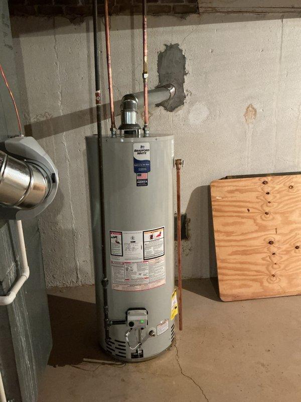 Completed standard installation of a 50-gallon Bradford White tanked water heater in basement utility area. Reconnected all copper supply and distribution lines to the new unit, ensuring proper connections at the top of the water heater with existing plumbing infrastructure. Verified all mechanical connections were secure and system was operational per manufacturer specifications.