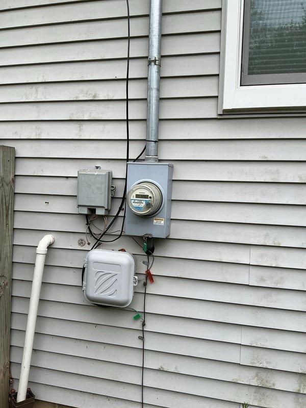 Completed HVAC system evaluation for replacement estimate on 25-year-old air conditioning system with basement-located coil and exterior condensing unit. System currently operational but utilizing R22 refrigerant, which is obsolete and no longer manufactured. Documented existing equipment configuration including outdoor condensing unit on concrete pad, PVC condensate drainage system with S-bend configuration mounted to exterior wall, electrical disconnect box, and utility connections. Assessed condition of aging components and provided comprehensive replacement options for complete system upgrade to modern, energy-efficient equipment with environmentally-compliant refrigerant.