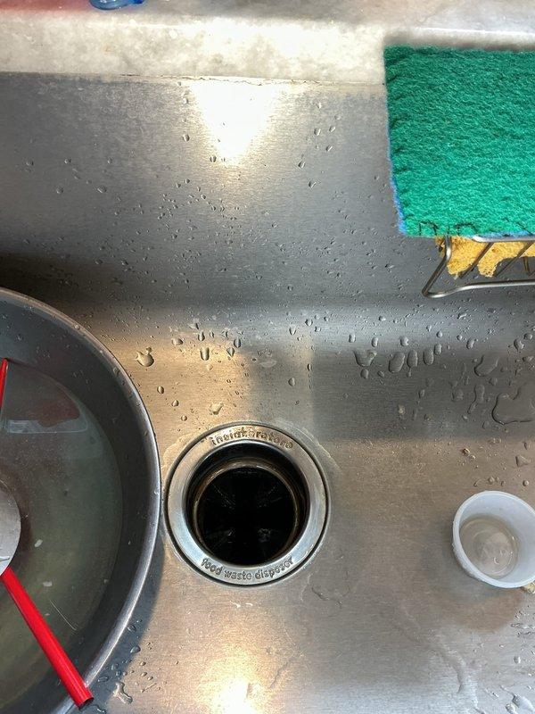 Responded to a water leak originating from the kitchen sink area. Upon inspection, identified a steady leak from the Badger 5 garbage disposal unit mounted beneath the sink. Examined all plumbing connections, including the disposal mounting flange, discharge pipes, and associated PVC and flexible hose connections. Diagnosed the source of the leak, tightened loose connections, and verified proper seal integrity at the disposal unit. Tested the system for proper drainage and confirmed the leak was resolved with no further water discharge observed.