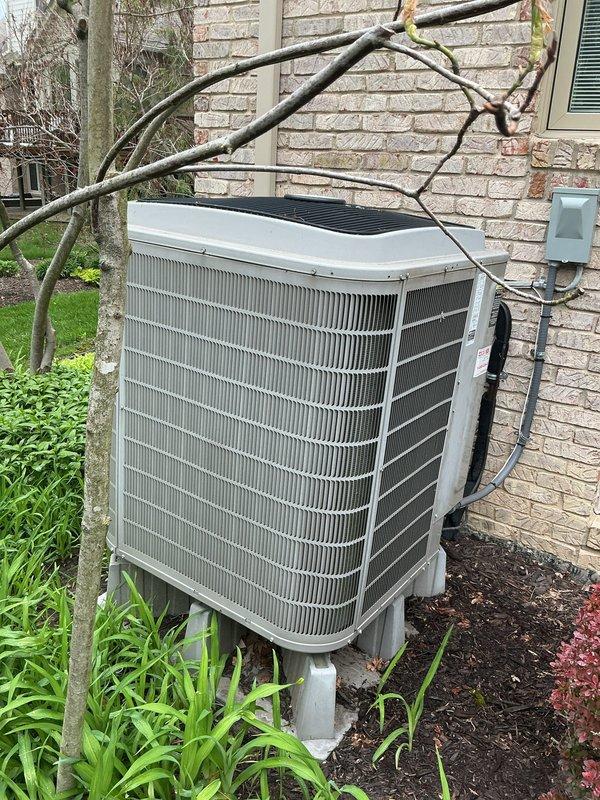 Completed comprehensive Gold AC inspection on 7-year-old air conditioning system with air handler located in basement. Unit confirmed operational with condenser positioned on exterior pad against brick wall, showing normal weathering and minor surface corrosion on housing. Advised customer that area surrounding condenser requires clearing of debris and any animal waste to maintain proper airflow and system efficiency.